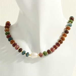 Détail du collier de perles en pierres précieuses colorées avec perle baroque et perles dorées