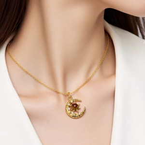 Collar de estrella y luna dorada con piedras de circón y gema verde en modelo