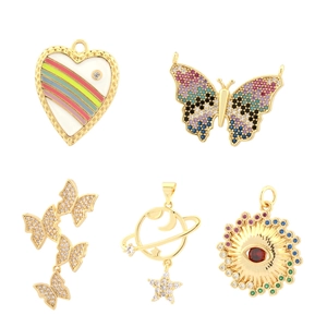 Detailed macro view of colorful zircon heart and butterfly pendants with gold plating