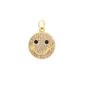 Detalle de un colgante de cara sonriente bañado en oro 18K con circonitas y ojos negros