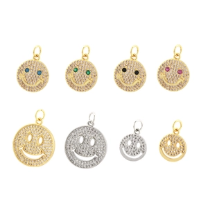 Detalle de colgantes de cara sonriente chapados en oro de 18K con circonitas y piedras