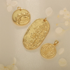 Drei goldgeprägte Medaillons mit floralen Motiven auf Seide und weißen getrockneten Blüten