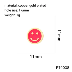 Detail of a 11mm gold-plated copper smiley face charm with red oil drip for jewelry making