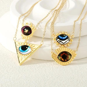 Macro view of gold evil eye pendants with intricate triangular and sunburst patterns