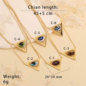 Detail view of gold vintage evil eye triangle pendant with size specifications