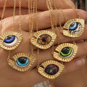 Golden evil eye triangle pendant necklaces with various iris designs held by hand