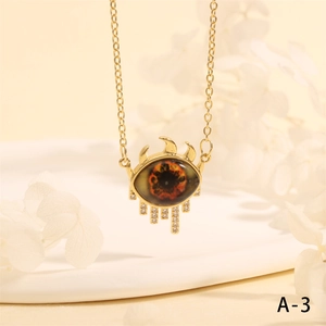 Macro shot of evil eye necklace pendant with orange pupil and white rhinestone details