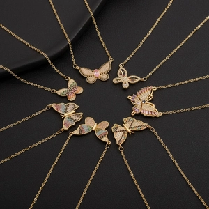 Detalle de colgantes de mariposa con circonitas de colores en cadenas doradas finas