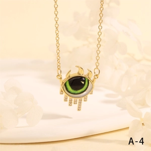 Macro shot of evil eye necklace with green iris and white zircon droplets in gold finish