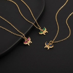 Detailed view of 18K gold plated butterfly pendants with red, green and blue gemstones