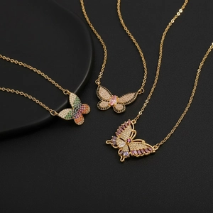 Primer plano de colgantes de mariposa con circonitas de colores bañados en oro