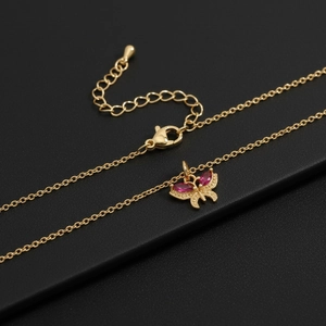 Golden butterfly pendant necklace with magenta stones on black display board