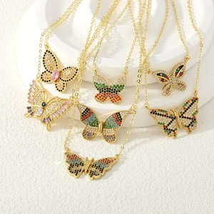 Detalle de colgante de mariposa con circonitas de colores y acabado chapado en oro