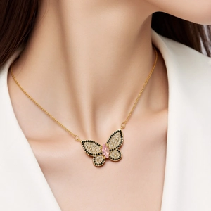 Detalle del colgante de mariposa con circonitas de colores en cadena dorada