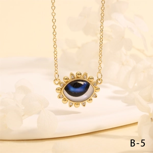 Macro shot of gold sunburst evil eye pendant necklace with crystals on white background