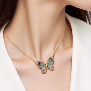 Primer plano de un collar con colgante de mariposa y circonitas de colores en una modelo