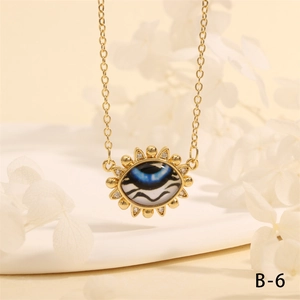 Detailed macro view of gold evil eye pendant necklace with crystals on beige background