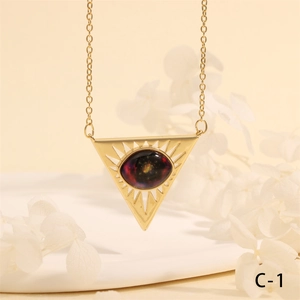 Macro detail of gold triangle necklace with black opal stone and sunburst engraving