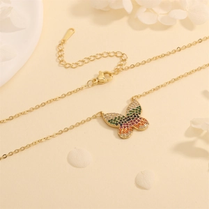 Detalle de un colgante de mariposa con circonitas arcoíris y cadena dorada ajustable