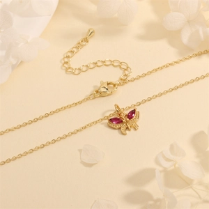 Macro shot of 18K gold plated butterfly pendant necklace with red marquise zircons