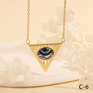 Detail of a golden triangle pendant with a blue evil eye motif on a thin link chain