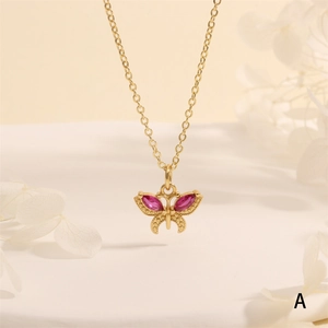 Detail of 18K gold butterfly pendant featuring vibrant pink marquise zircon gemstones