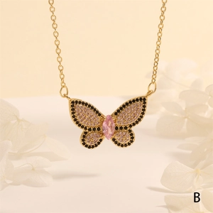Detalle de colgante de mariposa dorada con circones sobre pétalos de flores blancas