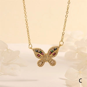 Detalle de un colgante de mariposa dorada con gemas de colores y pétalos blancos