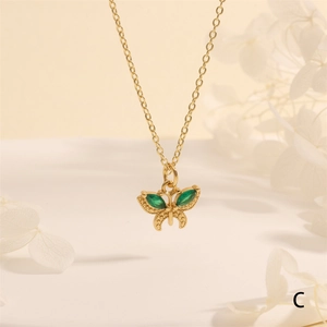 Detailed close-up of 18K gold plated butterfly pendant with green marquise zircon stones