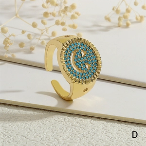 Detalle de anillo de sello dorado con incrustación 'G' en piedras azules y borde solar