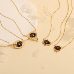 Detailed view of four vintage gold evil eye necklaces with colorful nebula pendants