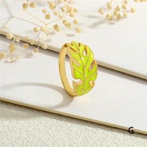 Detail of gold leaf ring featuring vibrant green enamel and tropical vein patterns