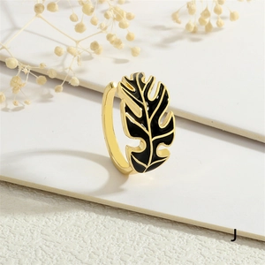 Detailed view of bohemian gold leaf open ring with black enamel inlay on white background