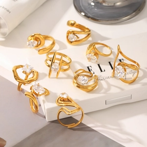 Set of gold stainless steel geometric rings with sparkling zircon stones on a pedestal