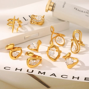 Detail of 9-piece gold geometric ring set with sparkling zircons on white background