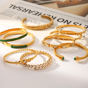 Detailed close-up of diverse 18k gold plated bracelets with zircons on magazine backdrop