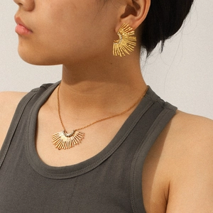 Model trägt goldenes Fächerschmuck-Set mit Sonnenstrahl-Textur und glänzendem Zirkon