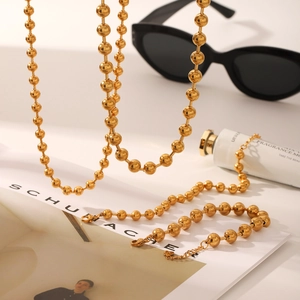 Detailed shot of 18K gold plated beaded ball chain necklace with lobster clasp closure
