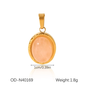 Macro detail showing an oval pink stone pendant with gold wavy edges and 1cm width scale