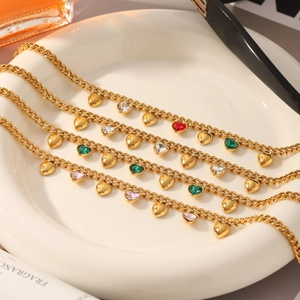 Elegante pulsera de corazón en acero dorado con dijes de circón de colores en plato