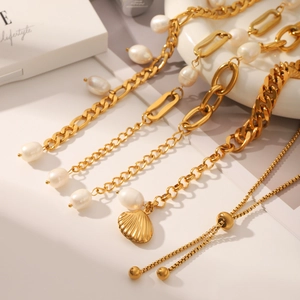 Détail d'un bracelet doré multicouche avec perles d'eau douce et pendentif coquillage