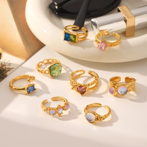Detail of 8-piece vintage gold alloy rings with assorted colorful gemstones and moonstones