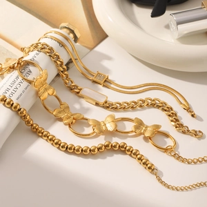 Detailed stack of 18K gold plated stainless steel bracelets with butterfly and zircon charms