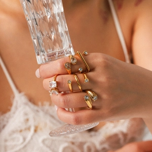 Stackable gold stainless steel rings with zircon stones shown on a model's hand