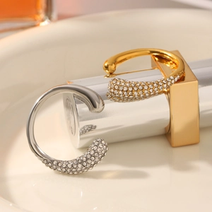 Macro detail of gold and silver plated C-shaped rings with sparkling zircon micro-pave setting