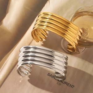 Detail of elegant gold and silver multi-layer wave cuff bracelets on luxury background