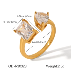 Detailed view of irregular golden ring with rectangular and pear-cut cubic zirconia