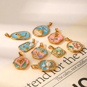 Artistic enamel charms with sea elements and pearls in gold frames on a magazine background
