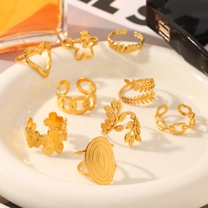 Detail shot of nine 18K gold-plated stainless steel rings with floral and leaf motifs