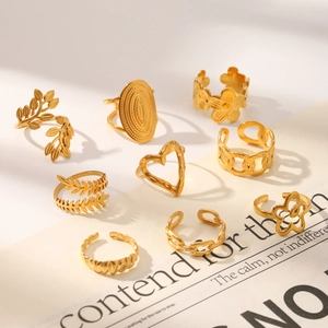 Detailed macro view of a 9-piece gold-plated stainless steel leaf and heart ring collection